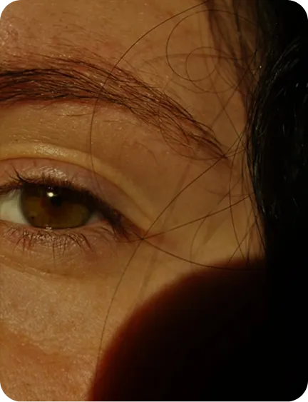 Close-up of a person's eye with visible eyebrow and hair.