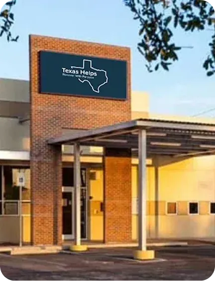 A building entrance with a sign reading "Texas Helps" featuring a silhouette of Texas.